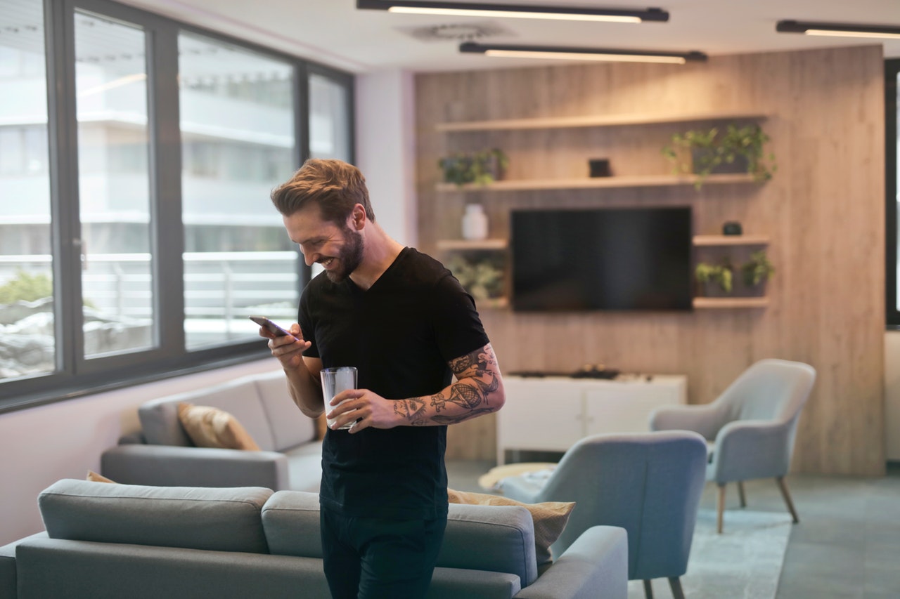 man-in-black-shirt-standing-while-holding-drinking-glass-942424